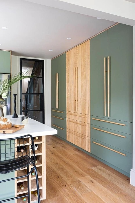 Sage green cabinets with gold cabinet hardware and elegant quartz countertops create a lovely contrast that really pops.